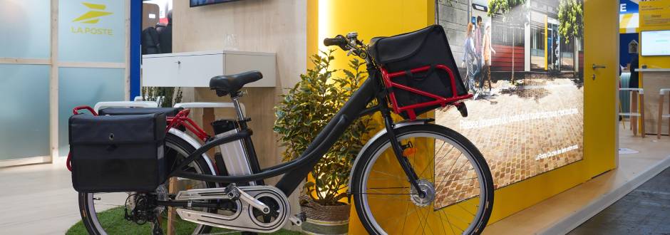exposition d’un vélo reconditionné de facteur La Poste lors d’un salon