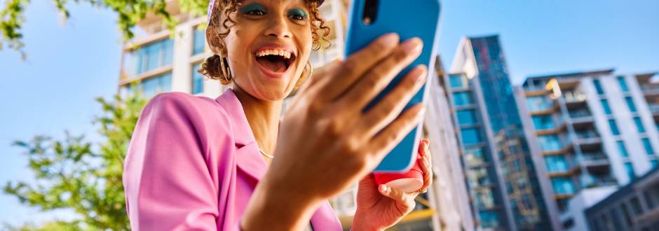 femme heureuse avec son smartphone en main