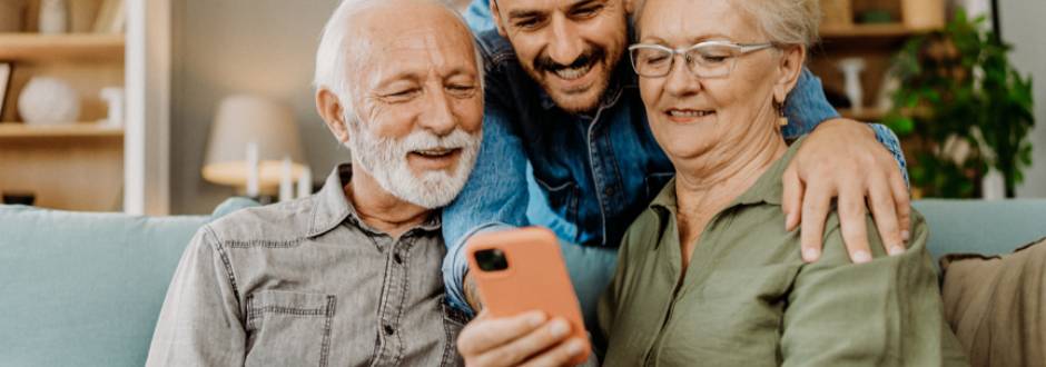 fils montrant à ses parents âgés comment utiliser un smartphone