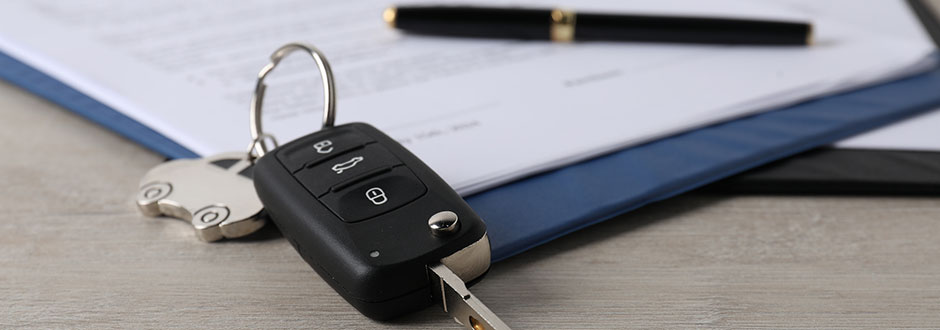 Clé de véhicule posée sur un contrat de location de voiture