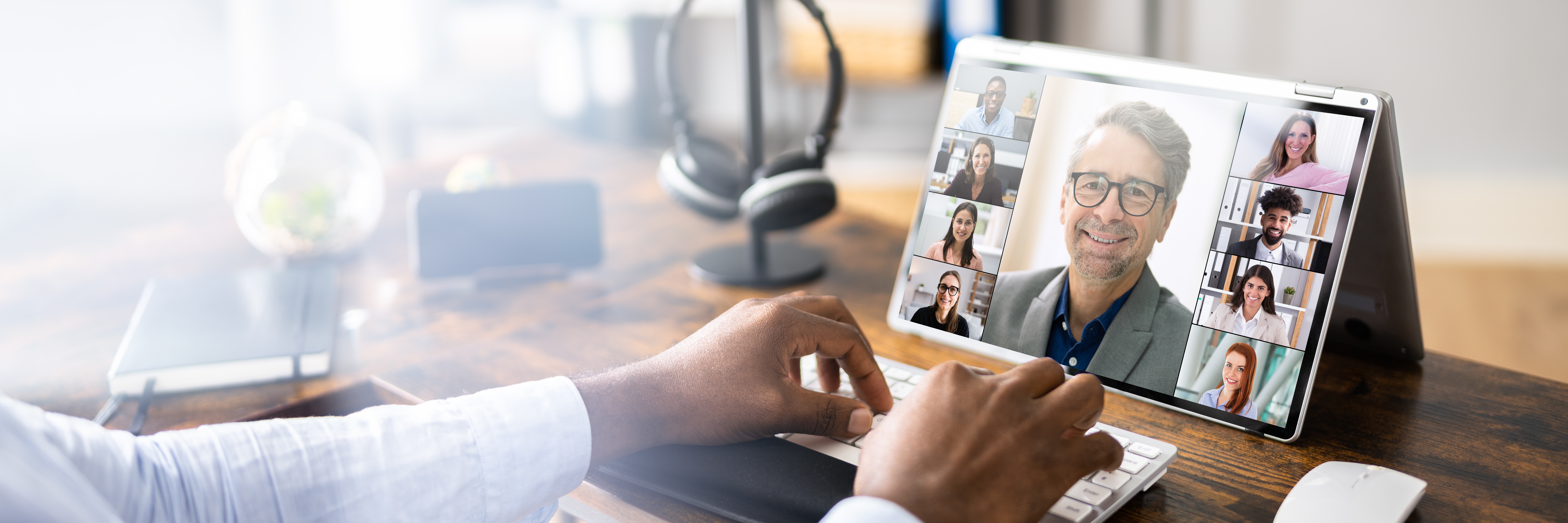 Poste de travail avec ordinateur affichant une visioconférence, illustrant la digitalisation des processus RH